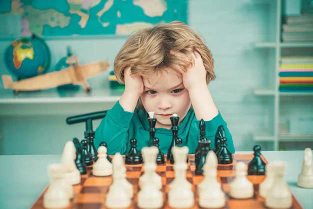 Child focusing on chess game showing concentration and cognitive development skills