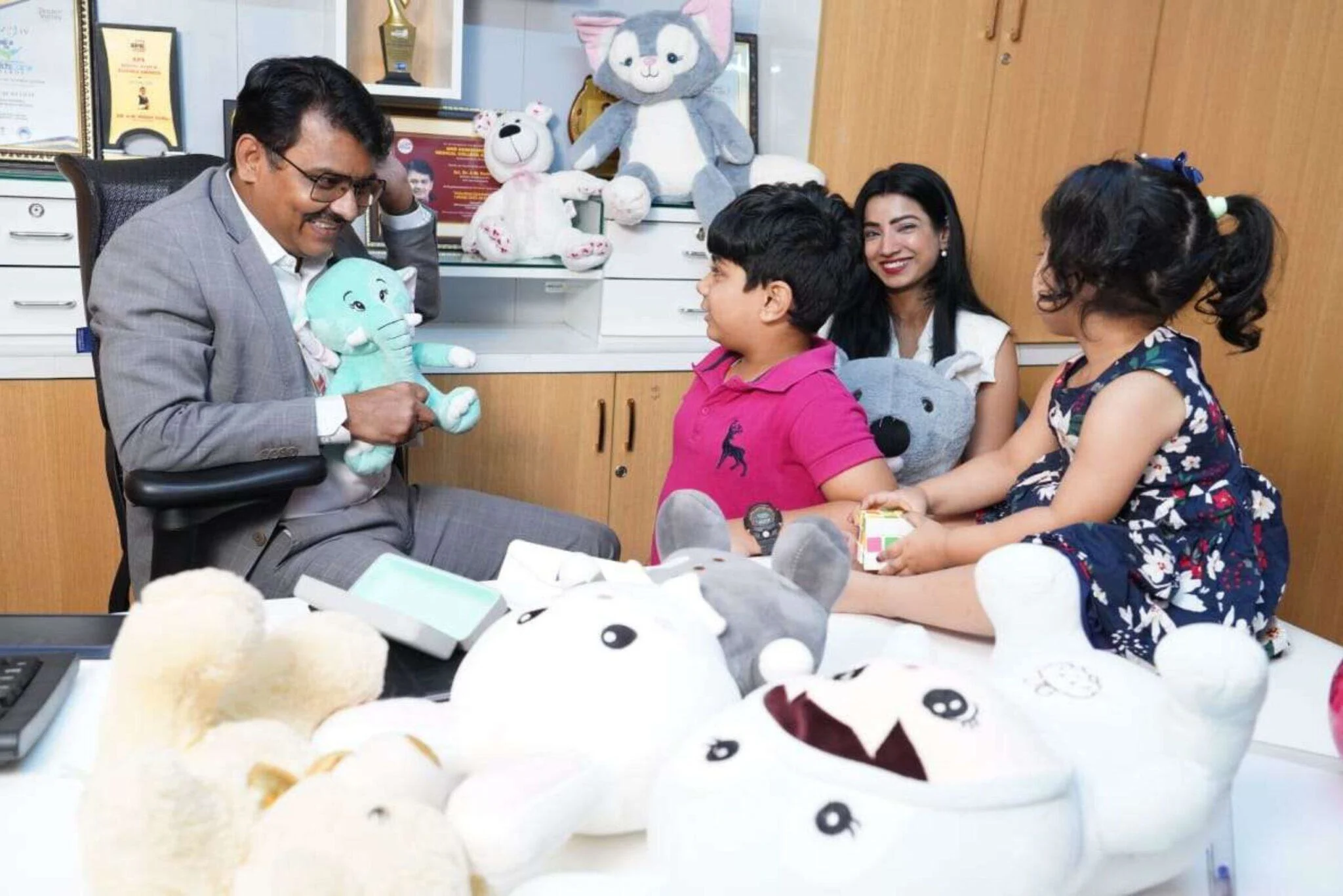 Doctor engaging children and parent in play therapy session to support autism development
