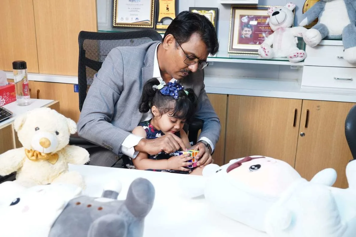 Doctor guiding a child in play therapy activity to support autism and cognitive development