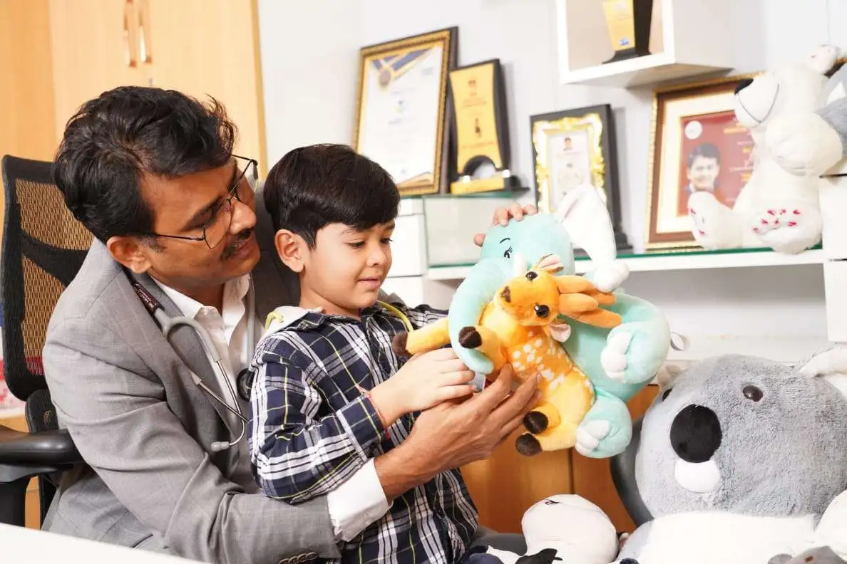 Doctor interacting with a child using toys during autism therapy session to support development