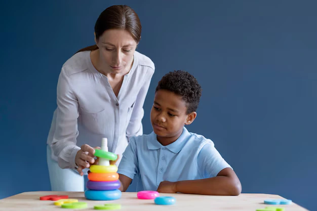 Therapist assisting child in occupational therapy activity to improve focus and motor skills